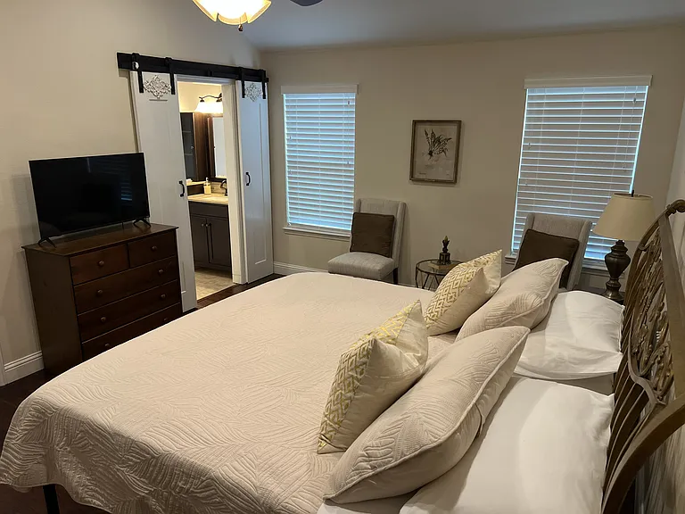 Spacious and relaxing primary bedroom retreat with elegant furnishings and vaulted ceilings