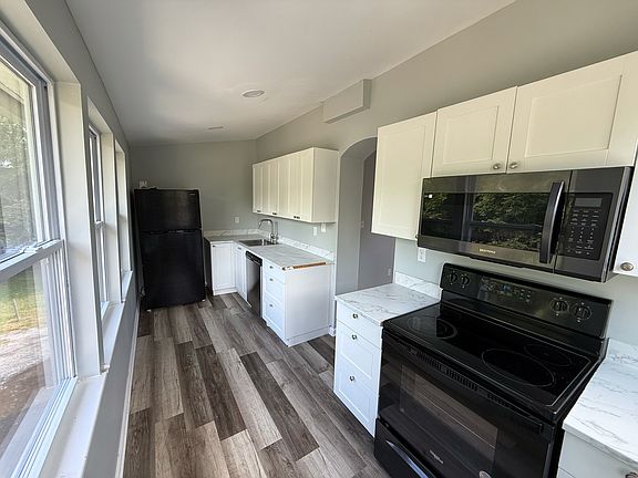 Kitchen equipped with fridge, dishwasher, microwave, and stove.
