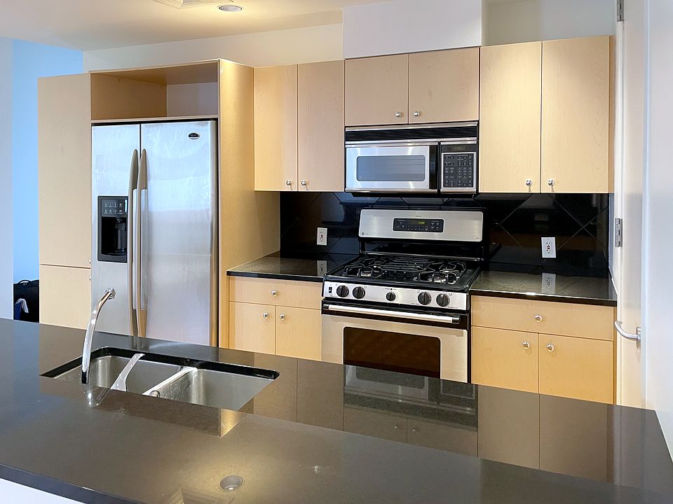 Sleek kitchen, with stainless steel appliances and quartz countertops.