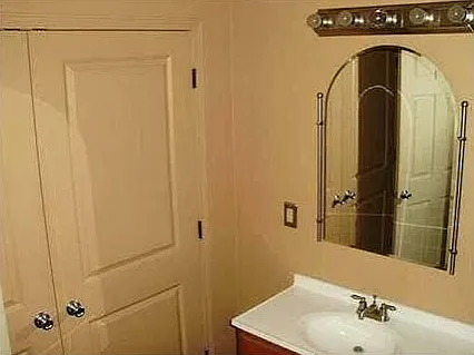 vanity sink and laundry closet in the shared full size bathroom