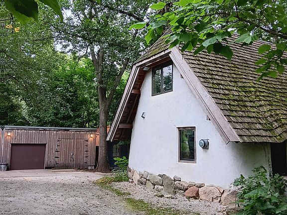 View from the north. The 1 garage bay which comes with the house can be seen in the background. The rest of the outbuilding to the right of the brown garage door is a workshop used by the owner.