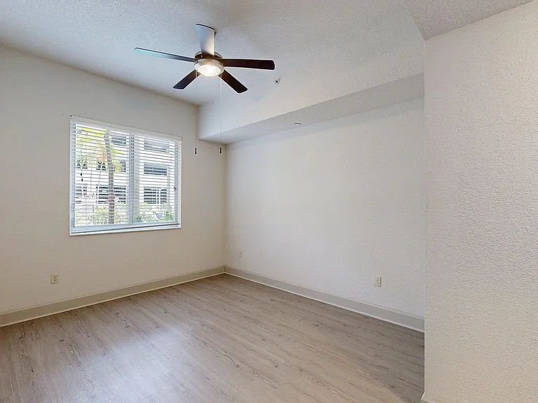Spacious apartment bedroom with wood style floor.