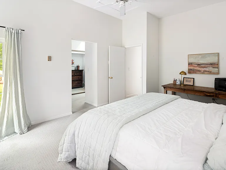 The master bedroom has a large antique table/desk/bench workspace.