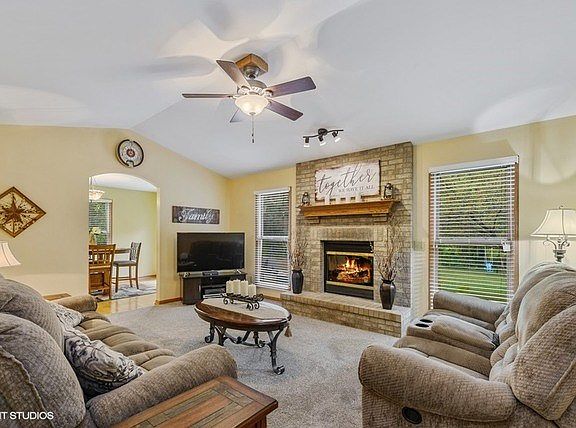 Great room with vaulted ceiling, gas fire place and a nice view of the tree lined back yard.