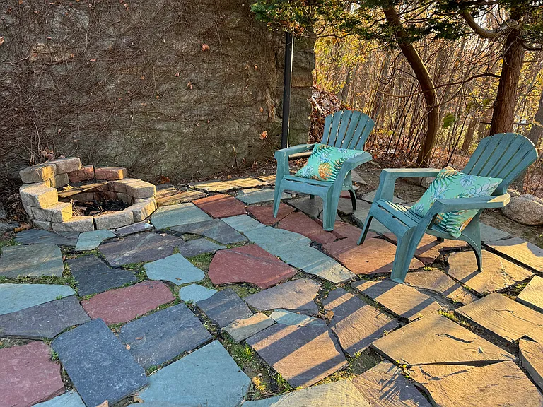Enjoy chillaxing in the great outdoors on the side yard slate patio. There is a small circular built in grill to use for grilling.