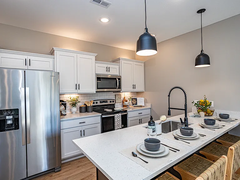 Kitchen with breakfast bar, stainless steel appliances, quartz countertops and industrial sink