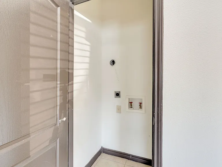 Hallway view in Merida Vista Apartments, Laredo, Texas, with a door and a light switch visible on the wall