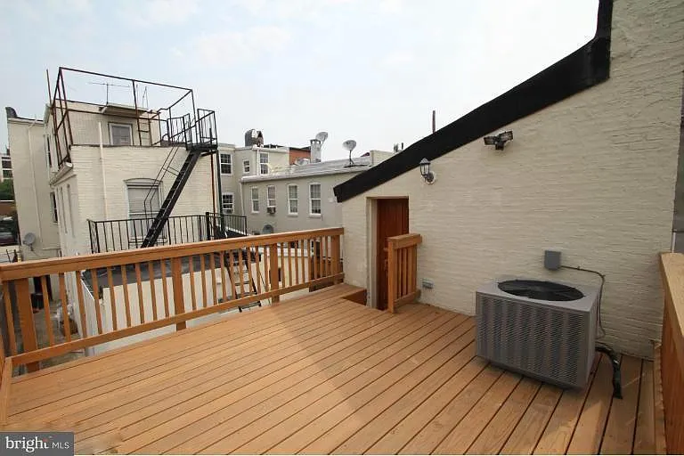 2nd floor: rooftop deck at back of house looking toward front of house and private, gated alley.