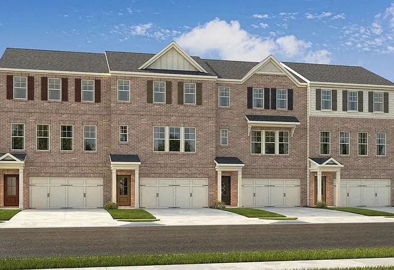 Exterior shot of Waverly Village, three story townhome with a private driveway and attached garage.