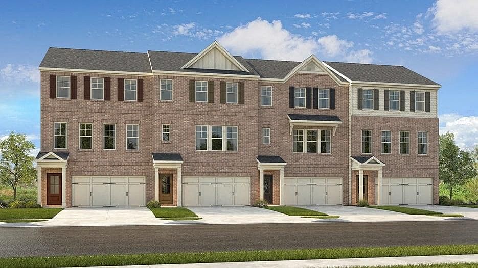 Exterior shot of Waverly Village, three story townhome with a private driveway and attached garage.