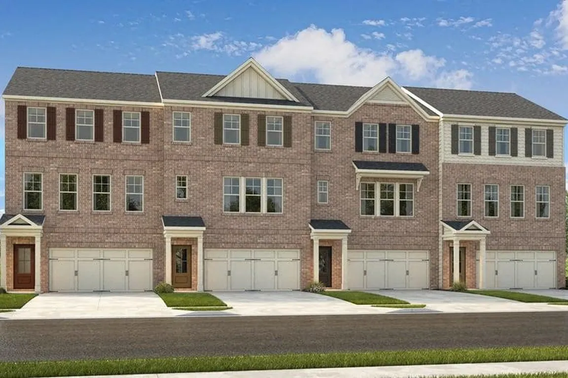 Exterior shot of Waverly Village, three story townhome with a private driveway and attached garage.