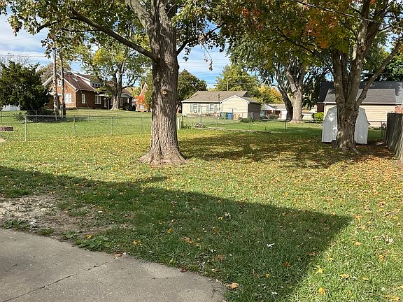 Fenced backyard of the home. Picture taken from the gravel driveway