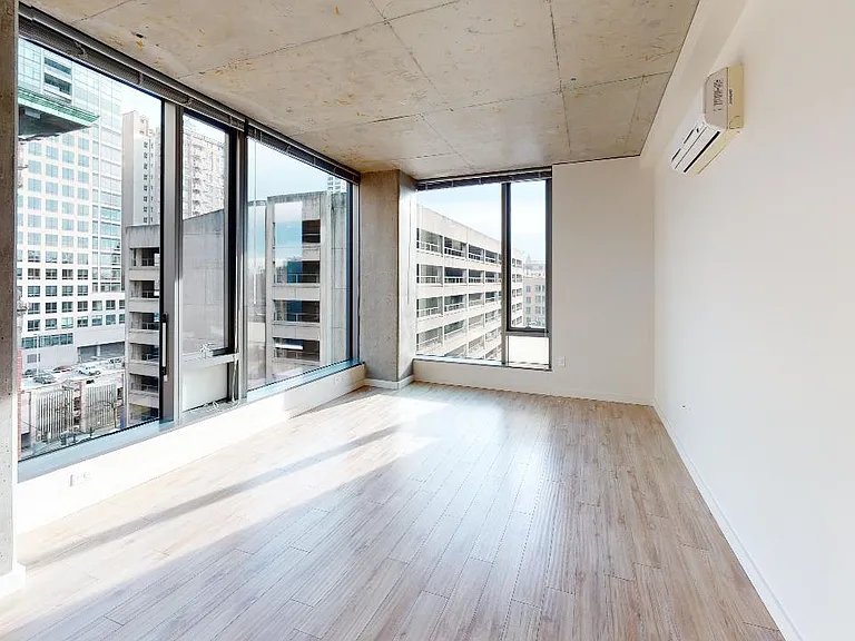 Apartment living room with wood-style flooring and floor-to-ceiling windows.
