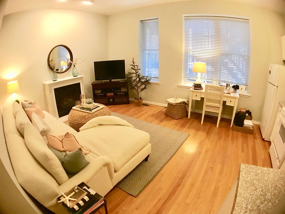 Living room, 10-foot ceilings, fireplace, hardwood floors throughout. Open to the kitchen.