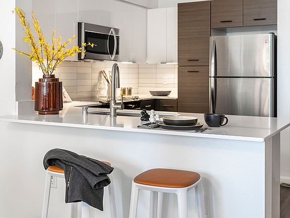 Apartment Kitchen with Stainless Steel Appliances, quartz counters and wood floors.
