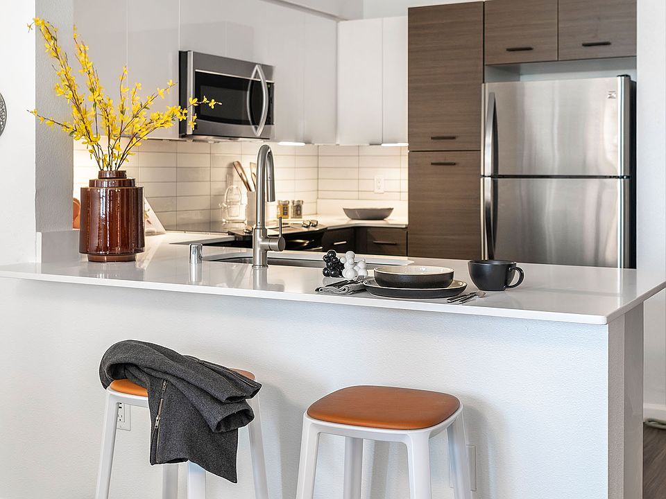Apartment Kitchen with Stainless Steel Appliances, quartz counters and wood floors.
