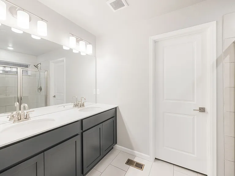 Primary bath with double vanity and glass-enclosed shower
