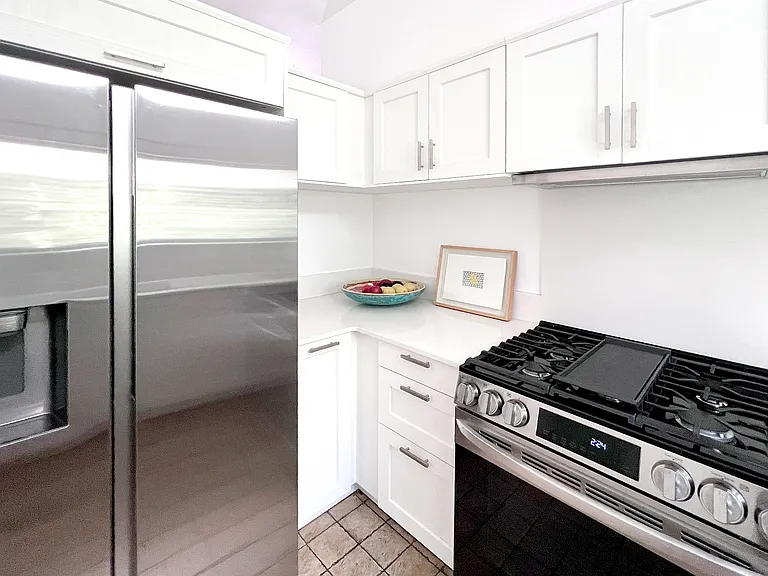 Fully renovated kitchen with brand-new quartz countertops and new premium appliances, including a high-end LG gas stove and Samsung appliances.