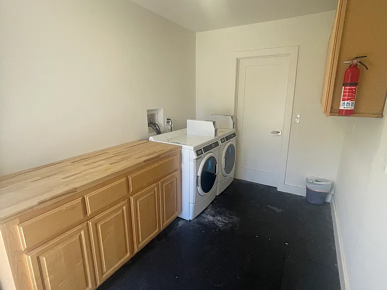 Shared Laundry with cabinets and folding counter.