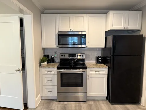 LVP Flooring Throughout. Stackable Laundry Unit to the left of the kitchen wall.