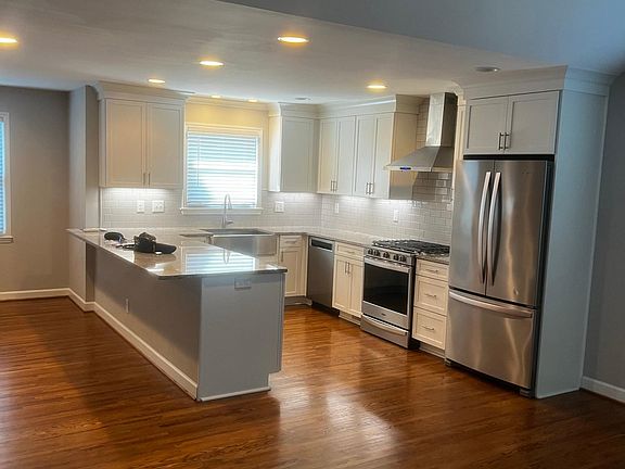 Newly remodeled kitchen with large peninsula looking out into the family room