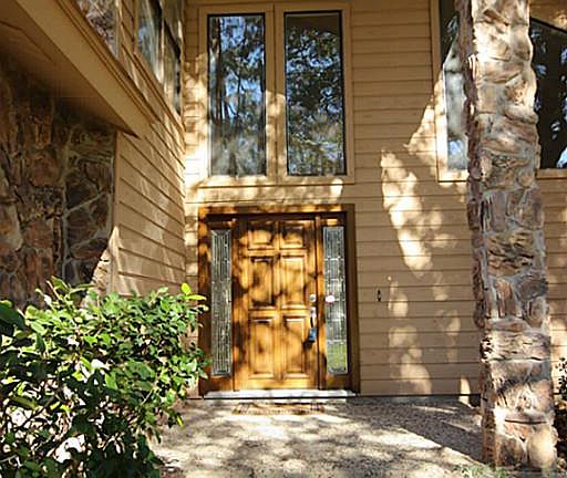 Walking up to the front door, you can appreciate the large windows, cozy front porch, and unique architecture of the home.