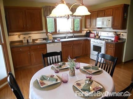 LARGE EAT-IN KITCHEN WITH UPDATES : CORIAN COUNTERS, SINK AND UNDER CABINET LIGHTING. APPLIANCES STA