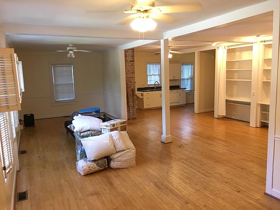 This viewpoint is from the right side of the living area. You can see the kitchen in the far corner and the ample bookshelf space to the rear of the living area.