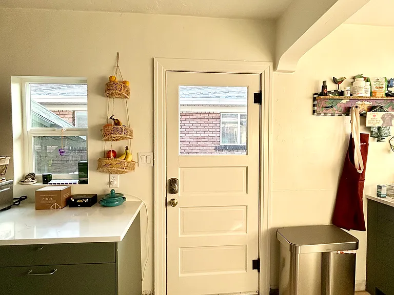 Back door to side of house, backyard access, and garage. Trash receptacles also stored on side of house.