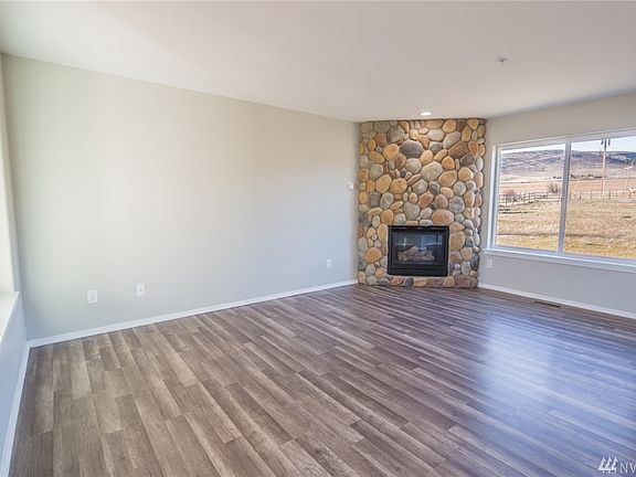 Spacious living room with gas fireplace in the corner.