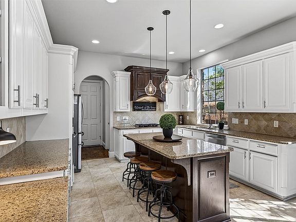 Light and bright kitchen with stainless steel appliances and white cabinets.