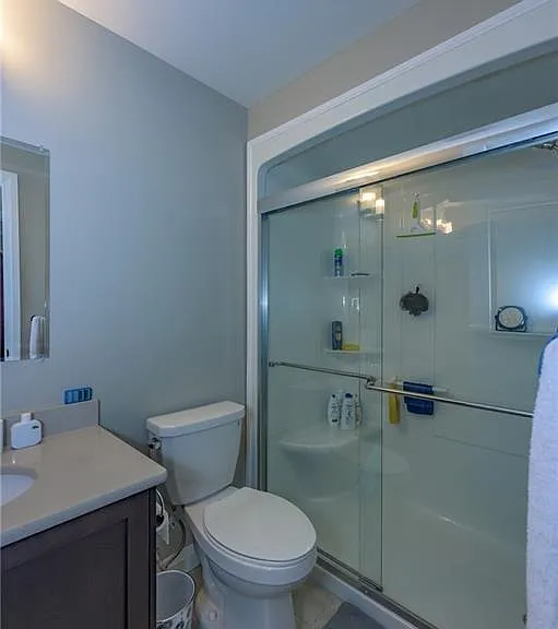 Bathroom w/ walk in shower and glass door.