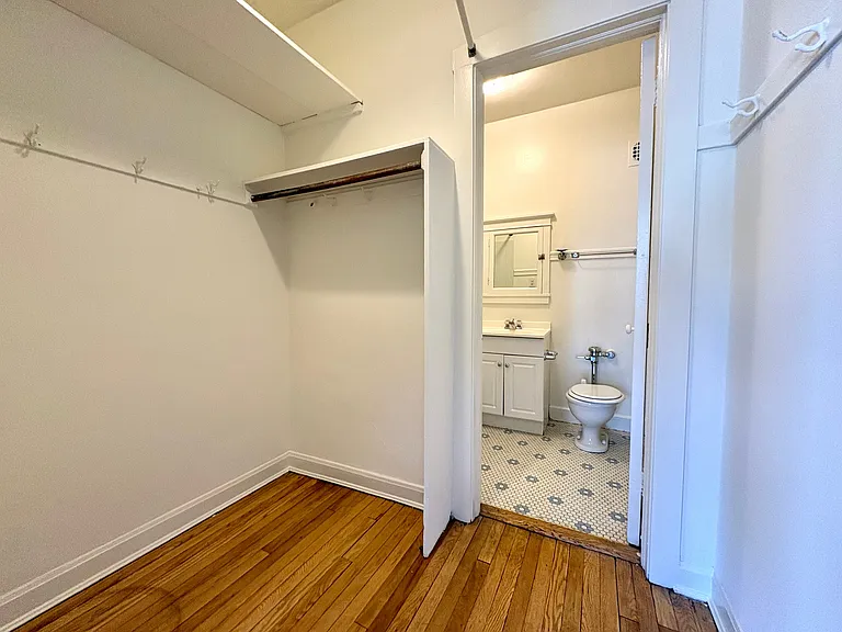 Inviting walk-in closet with hardwood floors leading to a modern bathroom with stylish fixtures. Inviting walk-in closet with hardwood floors leading to a modern bathroom with stylish fixtures.