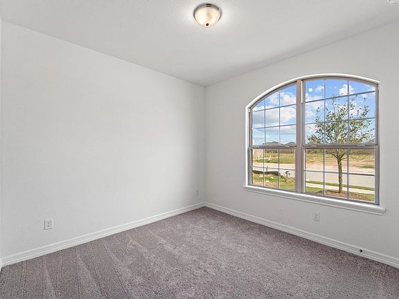 The second bedroom features plush carpet, fresh paint, closet, and a large window that lets in plent