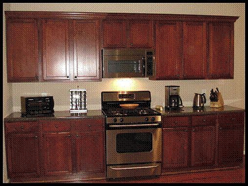 The kitchen has beautiful cherry tone cabinets and stainless steel appliances.