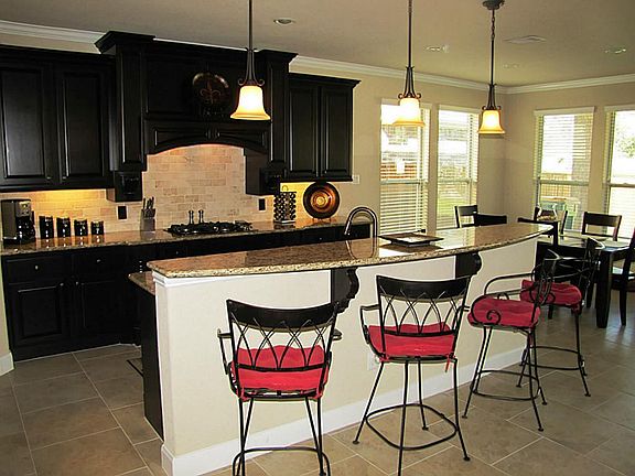 Open kitchen with breakfast bar. Raised panel cabinets with under cabinet lighting.