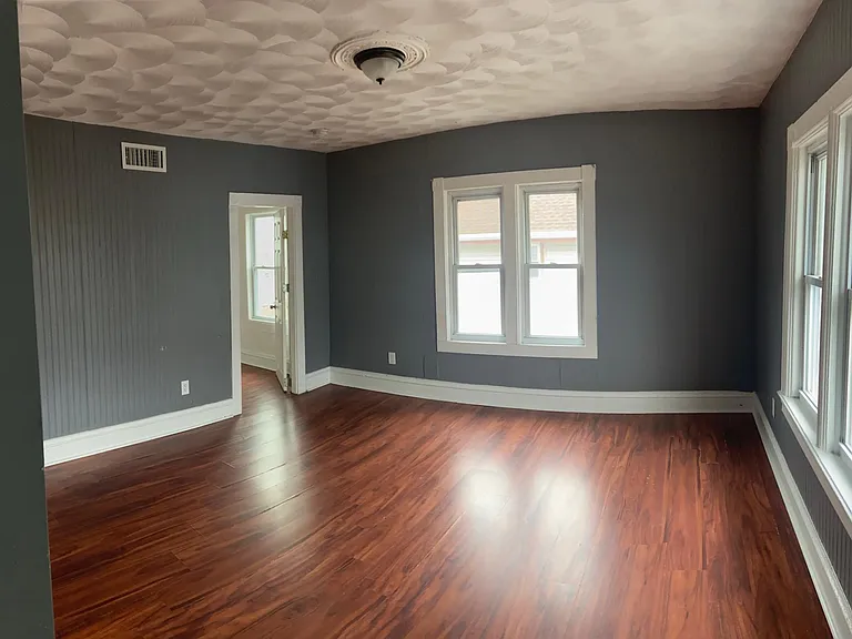 Living room space leading to master bedroom. Master bedroom is set off from the rest of the unit to provide more privacy