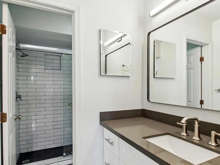 Fully renovated Master Bathroom with marble floors, new vanity, quartz countertop, new faucet fixture, built in medicine cabinet, designer mirror and light fixture with new towel rack. Walk-in tiled shower with penny tile floor and sliding glass doors.
