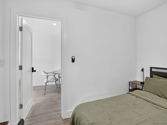 Private bedroom with a full bed, bedside table, and easy access to the adjacent common area for everyday convenience.