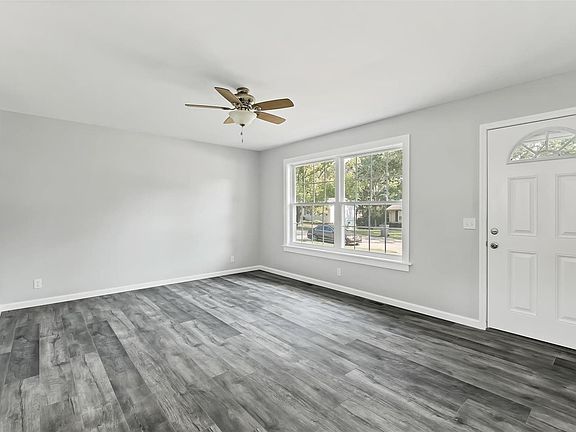 Living Room has new flooring - windows - front door - wood trim - ceiling fan.