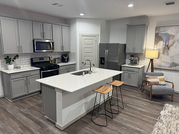 Kitchen equipped with stainless steel oven, stove, microwave, and fridge