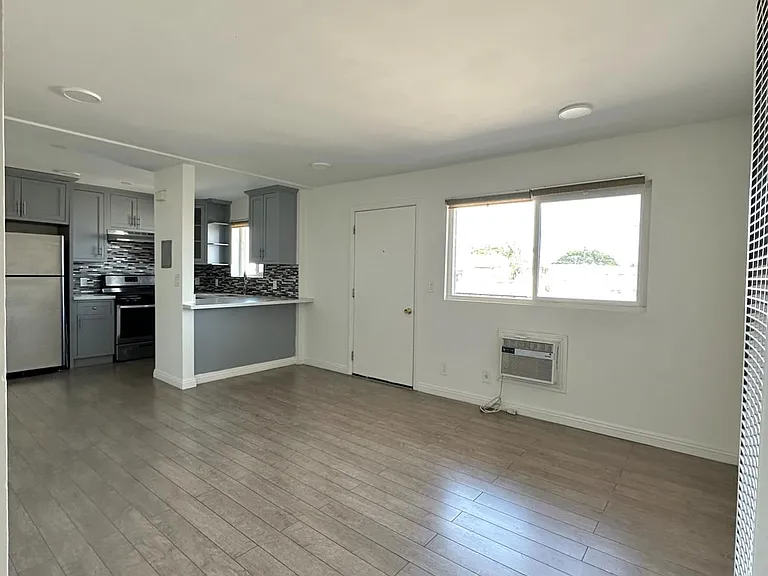 View of living room, dining room, and kitchen.