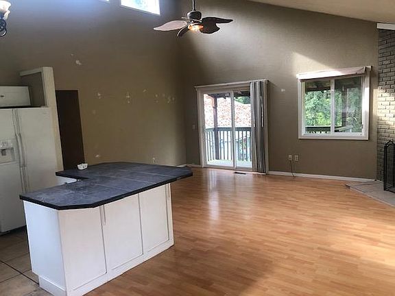 open concept living room/dining room/kitchen with two decks off this grand room with vaulted ceiling