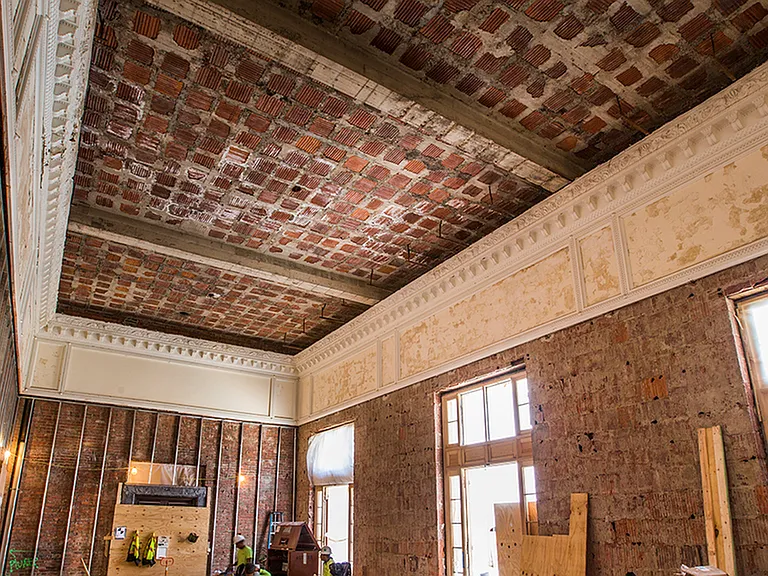 Before: Tall ceiling showing ornate crown molding during renovation