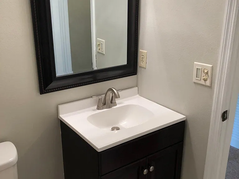 Spare bedroom bathroom with new vanity and mirror.