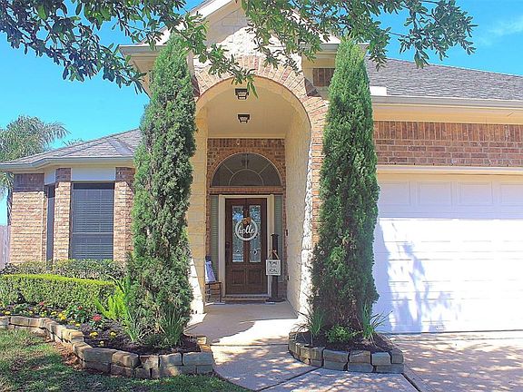 From the double-wide driveway you pass the well manicured landscaping to the inviting porch with a beautiful wood door with etched glass inserts.