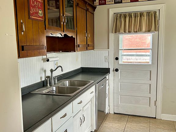 Kitchen looking towards door to back yard. Ceramic tile floor, refrigerator, dishwasher & stove included. Eat-in kitchen has space for table & chairs.