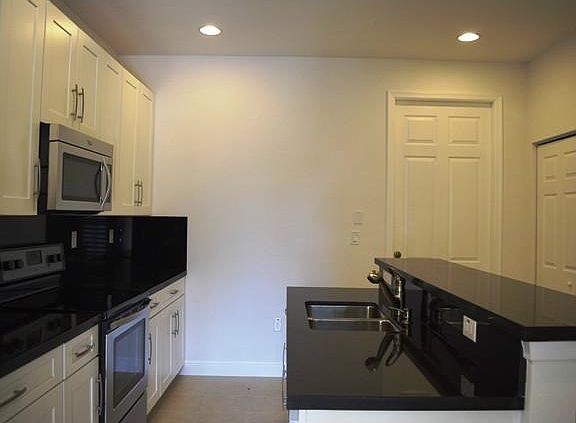 kitchen style is accented by Steel Bow hardware in Satin N