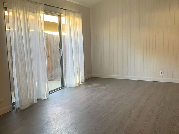 Large dining room with high ceilings, black exposed beams, and shiplap accent wall