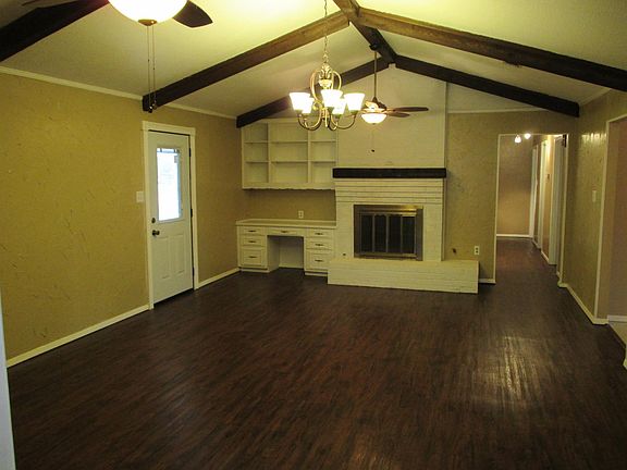 Family room with valuted ceiling and 2 ceiling fans